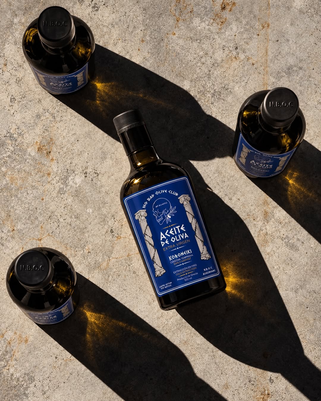 Bottles of No Bad Olive Club on a stone table. The cap reads N.B.O.C.
